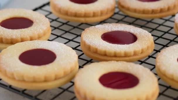 Jam cookies are on the wire rack. Female hands a making homemade biscuit shortbread cookies with jam. Kurabye cookies with raspberry jam. Christmas cookies with jam. — Stock Video