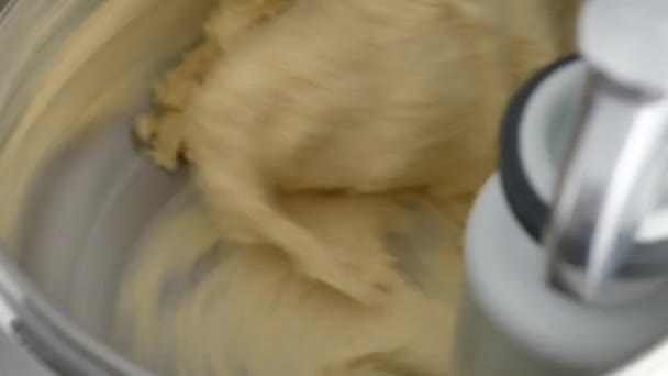 Machine kneading dough for donuts. Preparation of raw dough from butter, flour, sugar, milk, eggs and yeast in a dough mixer for industrial bakeries. Making homemade donuts. Close-up — Stock Video