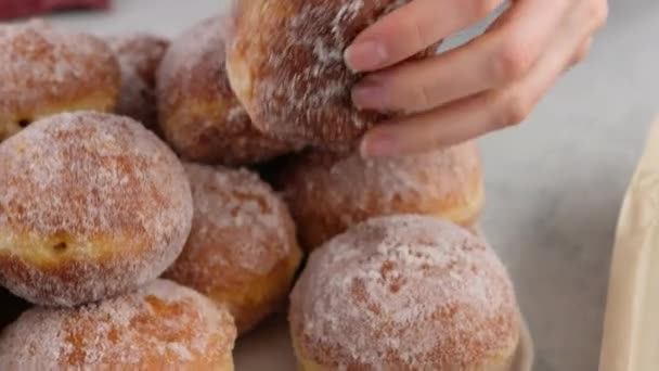 Berliners. Female hands lay donuts on a rectangular plate on a white background. Delicious sweet donuts. Making donuts with jam. — Stock Video