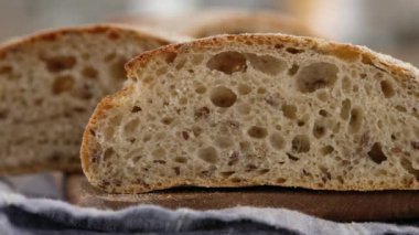 Kamera hareketi. Dilimlenmiş ekmek tahta bir tahtanın üzerinde yatıyor. Ekmek pişiriyorum. Ciabatta pişiriyorum. İtalyan ekmeği. Çavdar ekmeği. 4K