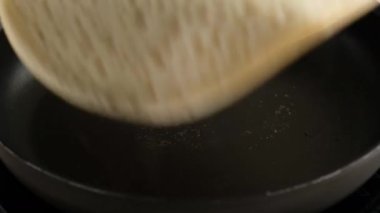 Tavada krep yapmak. İndüksiyon kızartma tavasında büyük yuvarlak gözleme. Krepten duman çıkıyor. Kefaretli krep. Delikli gözleme. Krep haftası. Rus geleneği.