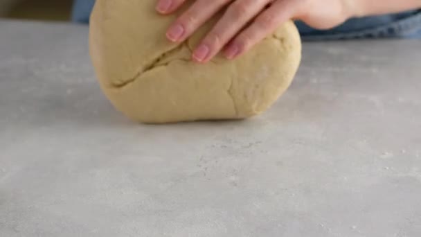 Belles mains féminines dans une cuisine professionnelle rouler la pâte pour faire du pain, pizza et petits pains. Du pain à la levure. Pain à base de lait, beurre, farine, œufs et levure. — Video