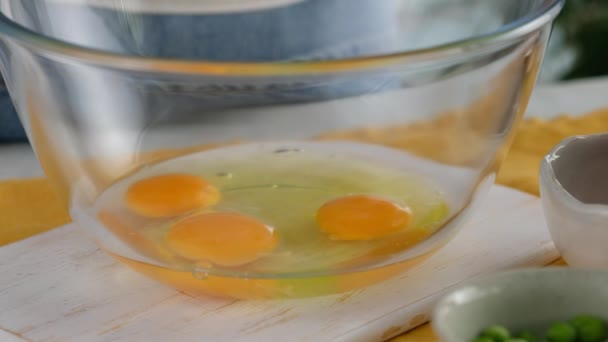 Зблизька. Яйце потрапляє до скляної миски для виготовлення броколі та сирного фритату у печеній страві. Італійський сніданок. Випечений нарізаний омлет з овочами і броколі. Здоровий сніданок. — стокове відео