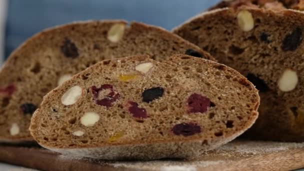 Kamerarörelse. Närbild. Vackert rustikt rågbröd ligger på en träskiva. Bröd av kornmalt, mjöl, salt. Zemgale bröd med torkade frukter. — Stockvideo