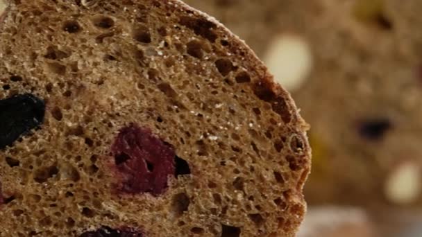 Ruch kamery. Zamknij drzwi. Piękny chleb żytni leży na drewnianej desce. Chleb ze słodu jęczmiennego, mąki, soli. Chleb z owoców cytrusowych. — Wideo stockowe