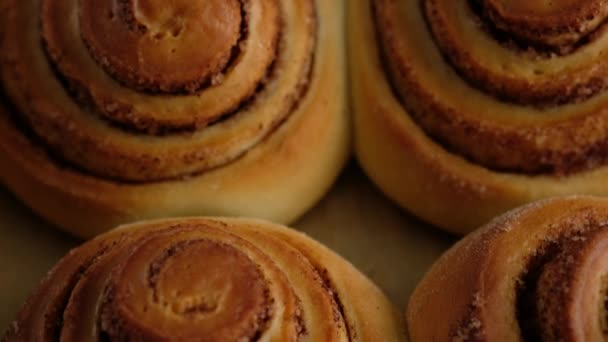 Una donna ha tirato fuori i panini alla cannella dal forno. Goffratura di formaggio dolce alla panna versando su rotoli di cannella Produzione di rotoli di cannella. Prodotti da forno. Panini alla cannella appetitosi — Video Stock