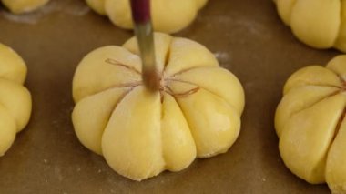 Kabak çöreği pişiriyorum. Dişi eller balkabağı çörekleri için hamuru yağlar, yakın plan. Sonbahar konsepti. Kahvaltılık çörekler. Taze çörekler.