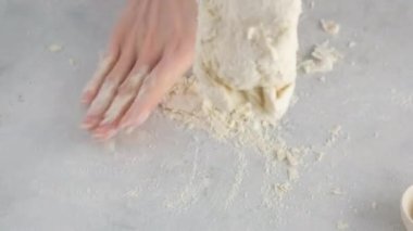 Kadın eli, ekmek yapmak için hamur yoğurur. Profesyonel bir fırında un, su, yağ ve tuzdan beyaz ekmek pişirmek.