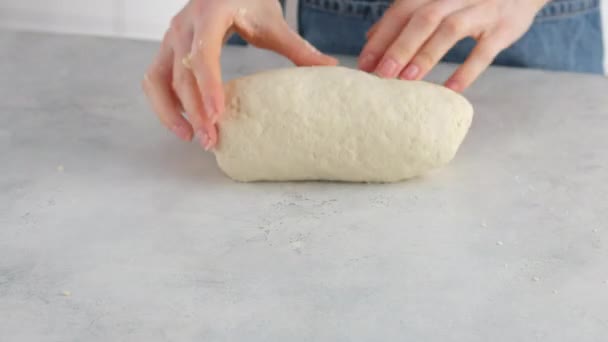 Tangan wanita berlutut adonan di atas meja cahaya untuk membuat roti gandum. Memasak roti putih di toko roti profesional dari tepung, air, minyak, garam. — Stok Video