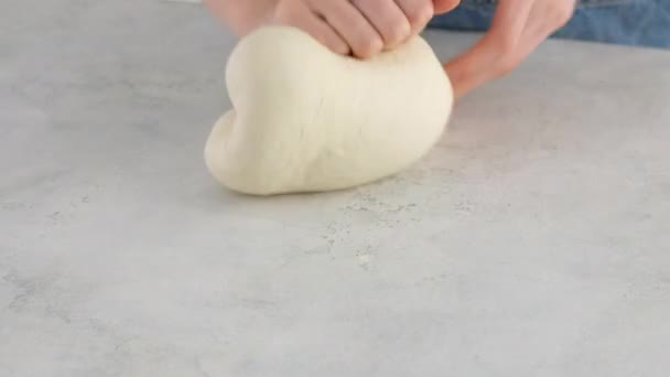 Detailní záběr ženských rukou hnětajících těsto na lehkém stolku pro výrobu pšeničného chleba. Vaření bílý chléb v profesionální pekárně z mouky, vody, oleje, soli. — Stock video