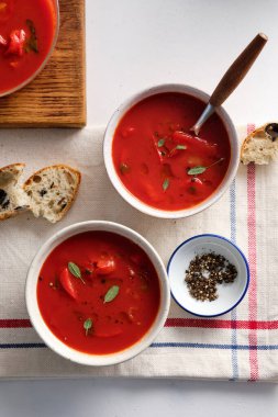 Beyaz arka planda beyaz bir kasede domates çorbası. Üst Manzara. Boşluğu kopyala