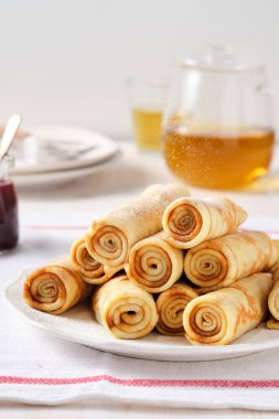 Krep, ballı ince krep ve beyaz tabakta çay..