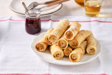 Krep, ballı ince krep ve beyaz tabakta çay..