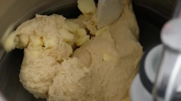 Machine à pétrir la pâte pour beignets. Préparation de pâte crue à partir de beurre, farine, sucre, lait, œufs et levure dans un mélangeur de pâte pour boulangeries industrielles. Faire des beignets maison. Gros plan — Video