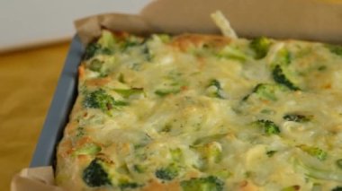 Yakın çekim kamera hareketi. Fırın kabında brokoli soslu frittata. İtalyan kahvaltısı. Fırında omlet, sebze ve brokoli ile servis tabağında. Sağlıklı kahvaltı..