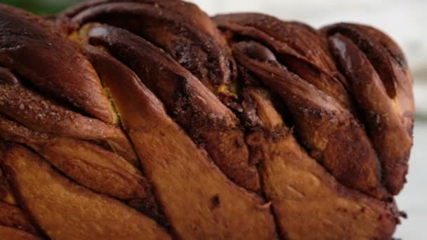 Mouvement de la caméra. Un petit pain en gros plan avec de la cannelle et du chocolat se trouve sur le porte-fil. Du pain et des petits pains. Du pain à la levure. Rouleaux de lait, beurre, farine, œufs et levure. — Video