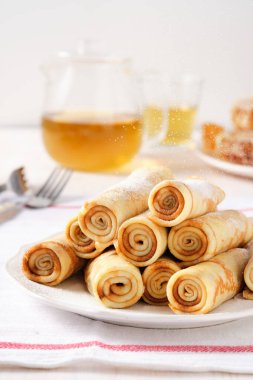 Krep, ballı ince krep ve beyaz tabakta çay..