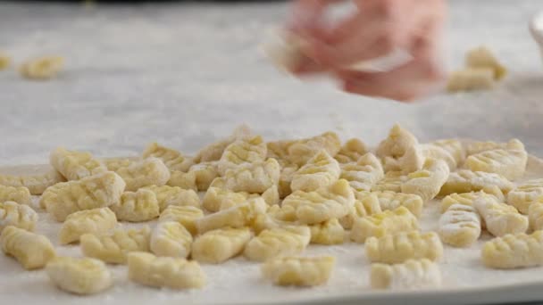 Kvinna som gör hemlagad pasta potatis gnocchi. Att släppa degen på den mjölade träytan i bitar. — Stockvideo