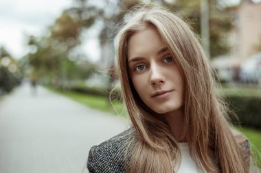 Güzel ve güzel sarı saçlı kadın manken ceketli hafifçe gülümseyen ve kameraya bakan.