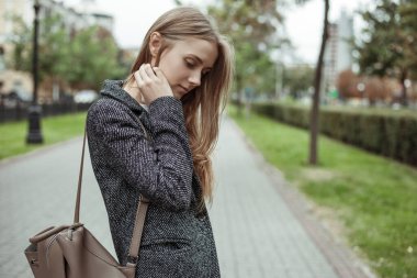 Romantik sarışın genç kadın caddede yürüyor.
