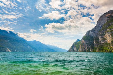 Güzel bir yaz gününde İtalya 'nın Garda Gölü' ndeki doğa manzarası. Mavi su, kayalar, dağlar, güneş ışığı ve berrak gökyüzü.