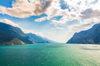 Garda Gölü 'ndeki doğa manzarası, hava manzarası, güzel bir yaz gününde İtalya. Mavi su, kayalar, dağlar, güneş ışığı ve berrak gökyüzü.