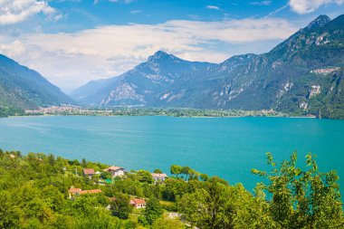 Idro İtalya Gölü 'nün güzel manzarası. Evler, ön plandaki küçük köy ve arka plandaki mavi su ve dağlar.. 