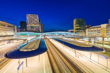 Alacakaranlıkta Utrecht merkez tren istasyonu. Modern çağdaş mimari ve Hollanda 'nın en büyük ve en önemli demiryolu taşıma merkezi.