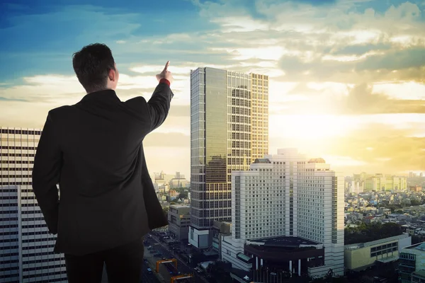 Business man looking the sky on the building rooftop — стоковое фото