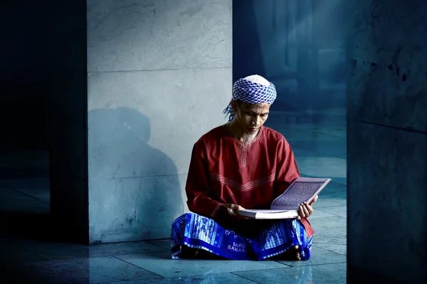Мусульманин, читающий священный Коран — стоковое фото