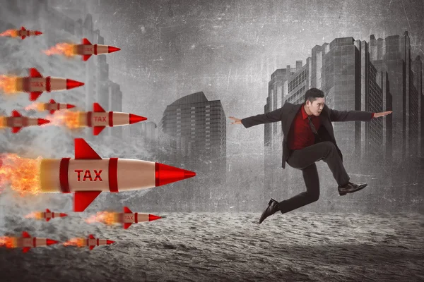 Hombre de negocios saltando de los cohetes fiscales — Foto de Stock
