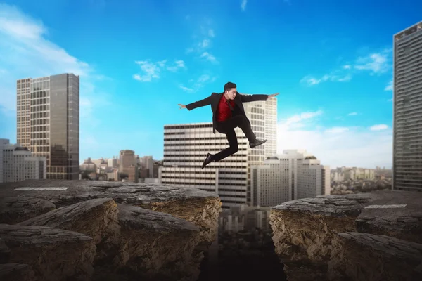 Business man jumping over broken road — Stock Photo, Image