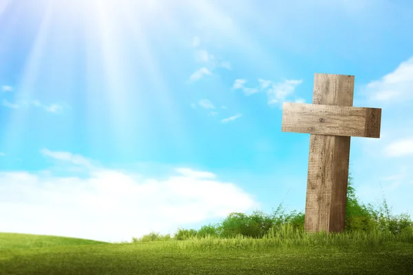 Wooden christian cross on green meadow — Stock Photo, Image