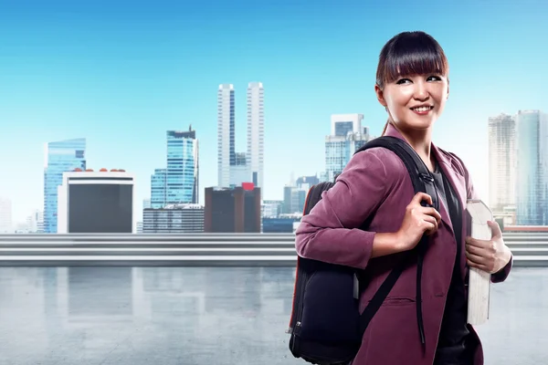 Female student holding book and backpack — Stock Photo, Image