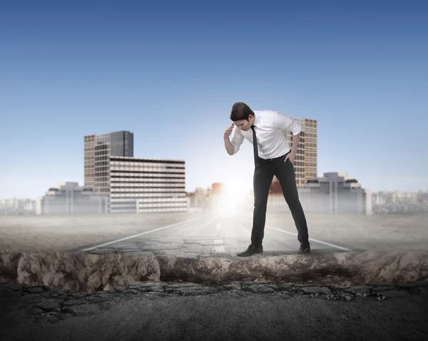 Hombre de negocios mirando hacia abajo en el camino roto — Foto de Stock