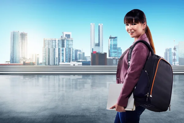 Female student holding book and backpack — Stock Photo, Image