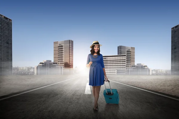 Asian woman on the street carrying suitcase — Stock Photo, Image