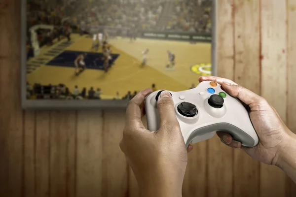 Manos sosteniendo el controlador de la consola de juegos — Foto de Stock