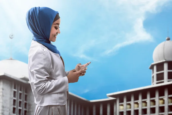 Mulher muçulmana digitando no celular — Fotografia de Stock