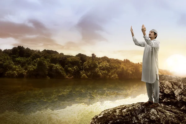 湖の上で祈って若いイスラム教徒の男性 — ストック写真