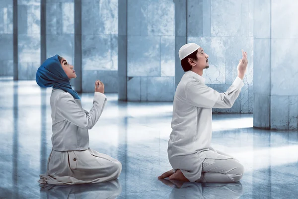 Молодая мусульманская пара молится — стоковое фото