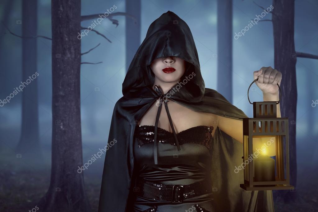 Witch woman holding lantern in forest Stock Photo by ©leolintang 120823610
