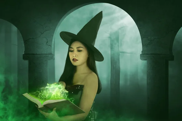 Mulher bruxa asiática segurando o livro — Fotografia de Stock