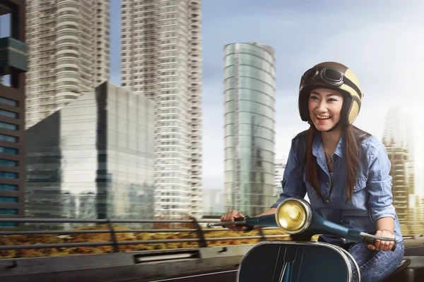 Молодая азиатская женщина на скутере — стоковое фото