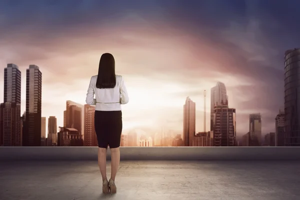 Asiatico businesswoman su roof looking a city — Foto Stock