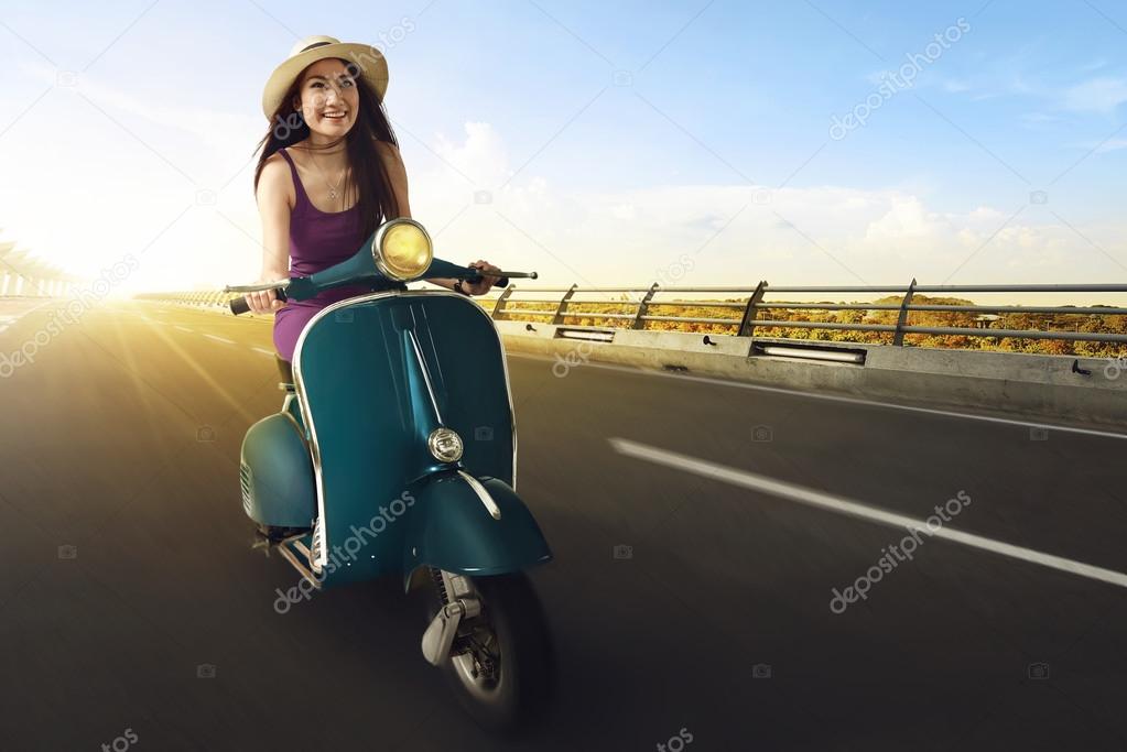 asian woman riding scooter