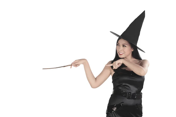 Jovem bruxa apontando com varinha mágica — Fotografia de Stock