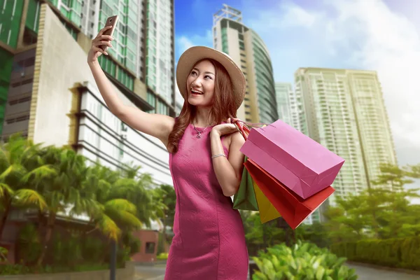 Красива азіатська жінка тримає сумки і приймає селфі з мобільним телефоном — стокове фото