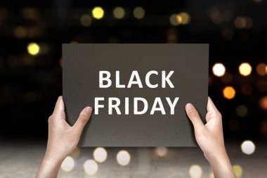 İnsan eli Kara Cuma metni olan bir tahtayı tutuyor. Kara Cuma konsepti