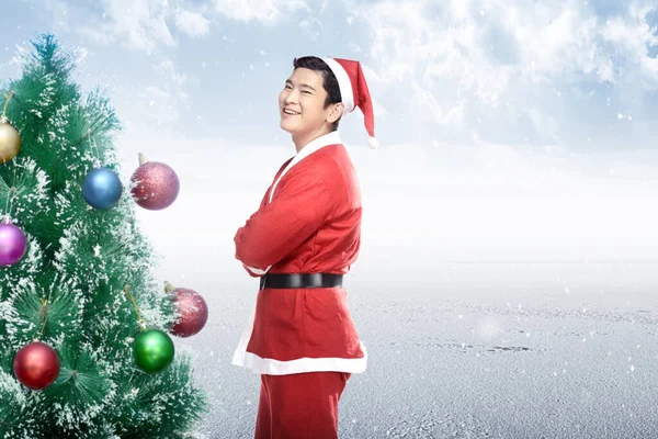 Asiatisk Man Santa Kostym Stående Med Julgran Med Snöfall Bakgrund — Stockfoto
